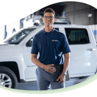 Service technician standing outside of vehicle smiling