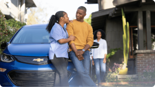couple talking in front of a car