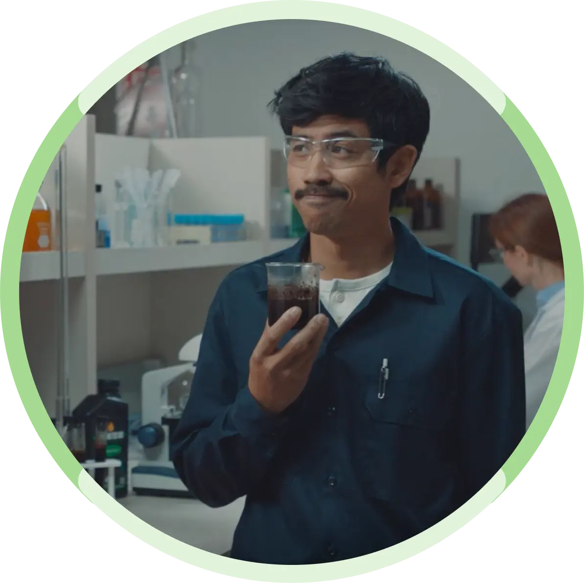 Man holding cup of liquid in lab