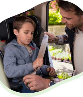 Father buckling child into carseat in the back seat of the vehicle
